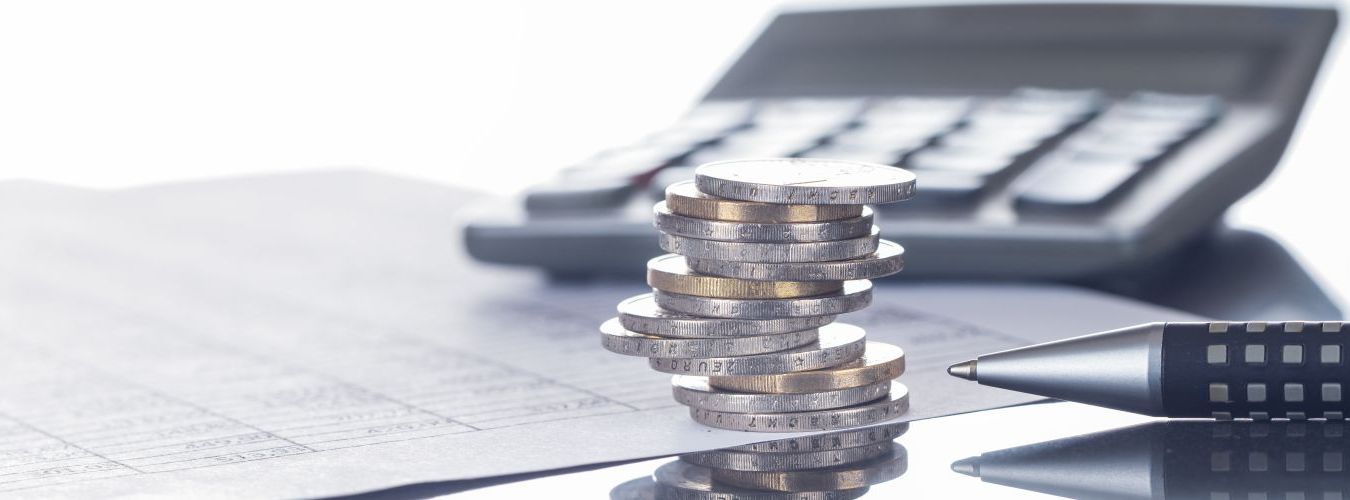 Finanzen, Euro, Münzstapel auf Tabellen mit Stift und Taschenrechner